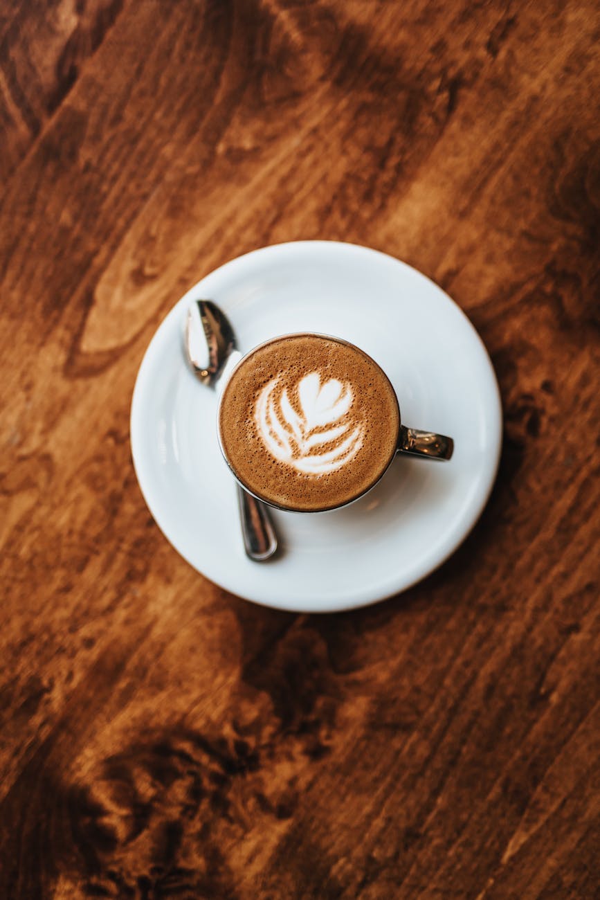 cappuccino in white ceramic cup on white ceramic saucer 